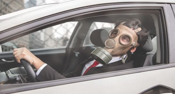 Man wearing gas mask sitting in car